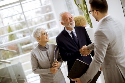Young businessman with senior clients standing in office Estate Planning Attorney Chicago IL